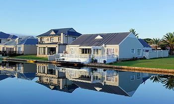 white single-story houses, body of water, luxury modern homes, peaceful lake, clear lake, daylight, architectural beauty, house reflection, modern architecture, waterfront homes, single-story homes