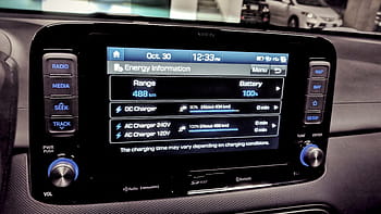 car dashboard, energy information, battery status, charging options, vehicle interior, digital display, car controls, navigation buttons, radio media, setup menu, date time