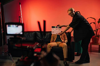 produzione del film, ciak, set interno, illuminazione drammatica, Donna che tiene tabella di clapper, troupe cinematografica, set cinematografico, team di produzione, riprese indoor, Setup di scena, configurazione dell'illuminazione