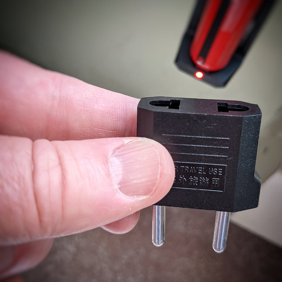 plug, adapter, travel, use, hand, holding, electrical, outlet, red, light, device