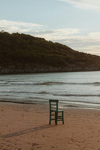 sedia sulla spiaggia, spiaggia tranquilla, onde gentili, collina verde, sedia solitaria, scena della spiaggia, vista mare, paesaggio della spiaggia, scena costiera, tranquillità in spiaggia