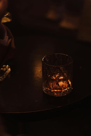 whisky üveg, közeli felvétel, elegáns üveg, Sötét asztal, meleg hangulat, hangulatos világítás, közeli fotózás, whiskyital, üvegáru, sötét környezet, meleg tónusok