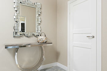 modern house, entrance door, decorative mirror, metallic console, stylish handbag, sleek entryway, contemporary design, interior decor, home entry, wall mirror, console table