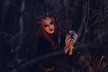 mystical woman, gothic attire, chalice, dark forest, eerie setting, black coach, gothic fashion, dark ambiance, forest scene, chalice holding, gothic woman