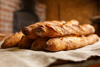 baked breads, rustic baguettes, freshly baked, cozy bakery, warm bread, stacked breads, artisan bread, bakery setting, homemade bread, bread loaf, bread stack