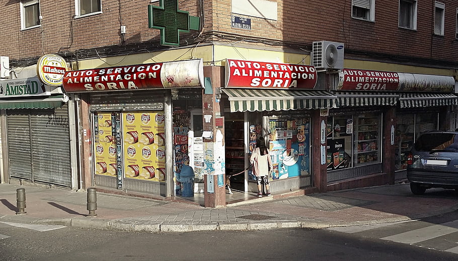 Madrid, Spain, Barrio de Usera, Auto-Servicio, Alimentacion Soria, convenience store, street corner, pharmacy sign, closed shutters, pedestrian, car