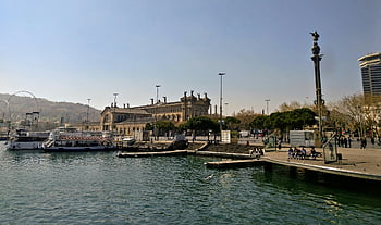 Barcelona port, historic architecture, waterfront activity, Brown Concrete Building, Barcelona waterfront, port area, historic buildings, waterfront view, Barcelona harbor, waterfront scene, historic port