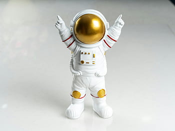 astronaut figurine, golden visor, toy astronaut, close-up, white background, space suit, hands raised, collectible toy, astronaut model, space-themed toy, astronaut figure