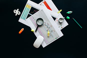 lente d'ingrandimento nera, scrivania da ufficio, documenti finanziari, Analisi aziendale, articoli di cancelleria, vista dall'alto, grafici finanziari, articoli da scrivania, lente d'ingrandimento, forniture per ufficio, relazioni finanziarie