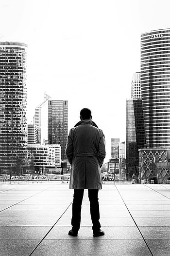 monochrome photo, man wearing trench coat, silhouette, modern urban cityscape, black and white, city skyline, urban landscape, man in coat, black and white photography, urban scene, cityscape photography