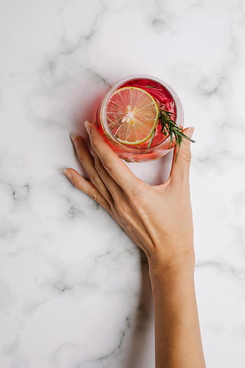 Håndholder drikke, Sitrusdrikk, rosmarin garnityr, marmor bakgrunn, forfriskende drink, glass drikke, hånd på marmor, sitrusskive, rosmarin takk, Drikkfotografering, marmoroverflate
