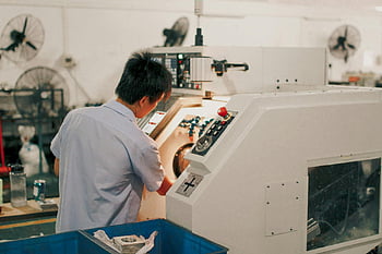 industrial machinery, factory setting, worker operating, industrial equipment, manufacturing process, factory worker, machinery control, industrial factory, machine operation, industrial worker, factory environment