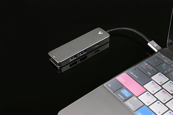 USBハブ、 ノートパソコン、 技術要素、 光沢のある黒い表面、 洗練されたデザイン、 USB接続、 コンピューターアクセサリー、 現代の技術、 電子機器、 ポータブルハブ、 キーボード