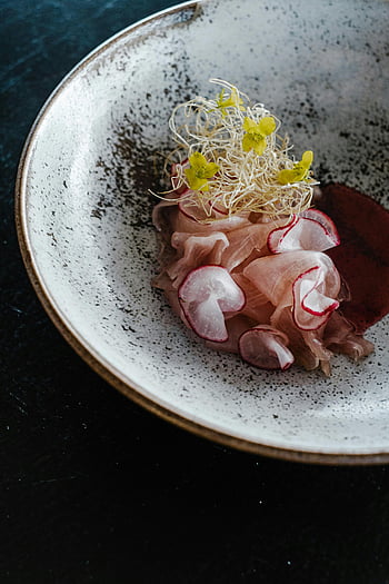 gourmet dish, close-up, radish, sprouts, speckled ceramic bowl, elegant presentation, fine dining, culinary art, food photography, high-end cuisine, plate presentation