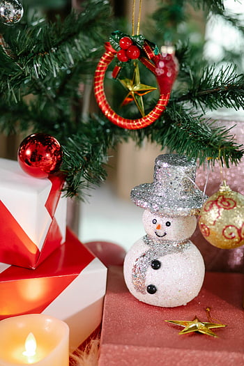 julpynt, snögubbe prydnad, presentförpackningar, julgran, mysig scen, festliga ornament, semesterinredning, rött och guld, julklappar, ljus ljus, stjärndekoration