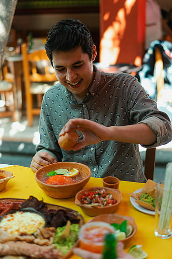 mexické jídlo, mladý muž, Barevné jídlo, pulzující restaurace, usmívající se, těší, mexická kuchyně, stolování, nastavení tabulky, atmosféra restaurace, fotografování potravin