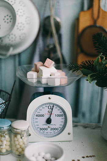 vintage kitchen scale, sugar cubes, rustic kitchen, shallow focus photography, gram scale, kitchen setting, marshmallows, kitchen decor, kitchen tools, vintage decor, rustic decor