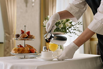 Luxusní snídaně, Čerstvé pečivo, nalévání kávy, bílý keramický pohár, elegantní stolničení, Snídaně, nalít kávu, bílé rukavice, stupňový podnos, elegantní stolování