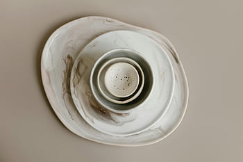 stacked ceramic plates, minimalist flatlay, ceramic dishes, natural marble pattern, stacked plates, flatlay photography, ceramic tableware, modern tableware, minimalist design, marble effect, ceramic bowls
