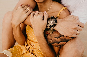 couple embracing, warm intimate, close-up, stylish wristwatch, tattoo, yellow dress, polka dots, engagement ring, romantic moment, skin tone, jewelry