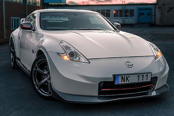 White Nissan 370Z, auto sportiva, contesto urbano, Norrtälje, Svezia, auto parcheggiata, Logo Nissan, targa auto, fari dell'auto, ruote di auto, Auto esterno