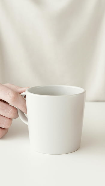 biały kubek, ręka trzyma kubek, minimalistyczny design, zdjęcie zbliżenie, zwykły biały kubek, Minimalistyczny kubek, białe tło, prosta konstrukcja, biały kubek kawy, filiżanka białej herbaty