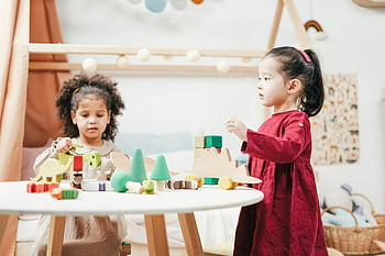 bawiące się dzieci, drewniane zabawki, Jasny pokój zabaw, tematy edukacyjne, dwoje dzieci, angażujące zabawki, zajęcia w pokoju zabaw, gra edukacyjna, Rozwój dziecka, zabawa w pomieszczeniu, interakcja zabawek