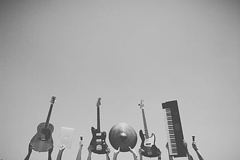 grayscale photography, music instruments, raised in air, clear blue sky, musical instruments, tech, guitars, keyboard, drum cymbal, black and white, outdoor music scene