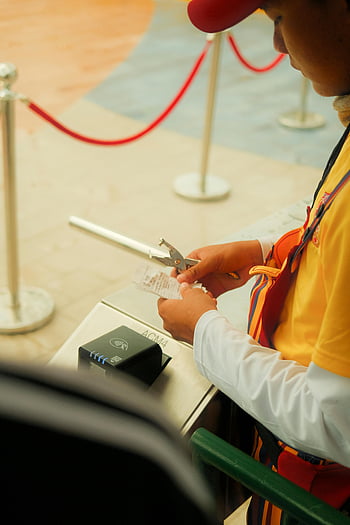 worker checking tickets, event gate, ticket processing, uniformed worker, visitor entry, event staff, ticket validation, event security, ticket scanner, event management, event entrance