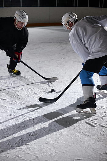 men, white helmet, playing hockey, ice hockey players, intense faceoff, indoor rink, sports action, hockey sticks, puck, athletic competition, winter sports