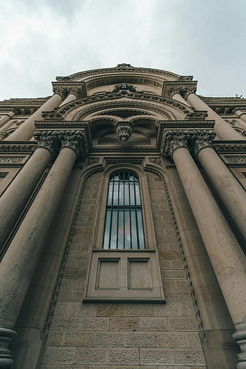 신고전주의 건물, 회색 콘크리트, 아치형 창, 인상적인 기둥들, 낮은 각도보기, 건물 외관, 건축 설계, 역사적인 건축물, 도시 경관, 석조 구조물, 고전적 스타일