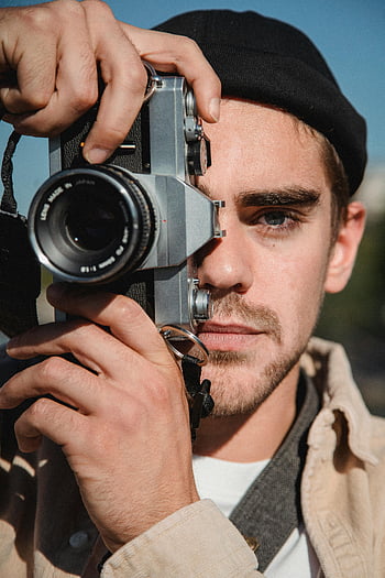 man in black beanie, black and silver camera, vintage camera, young man, outdoor city portrait, photography, urban photography, street photography, photographer, cityscape, outdoor photography