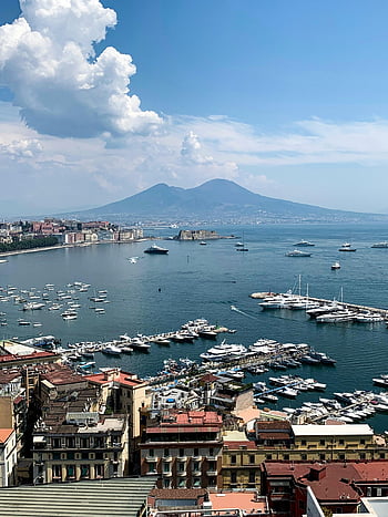 Napoli Marina, Monte Vesuvio, vista aerea, edifici della città, corpo d'acqua, cielo blu luminoso, barche marina, città costiera, paesaggio italiano, vista panoramica, napoli italia