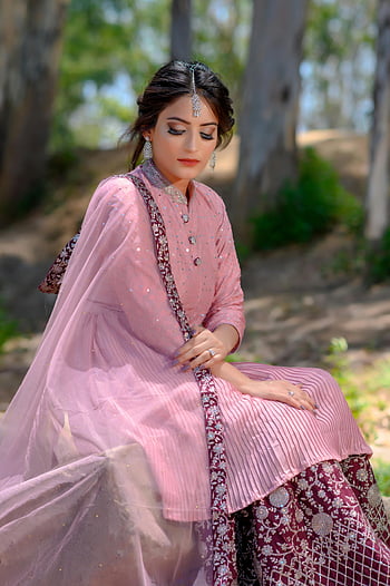 Femme en robe rose, accessoires indiens traditionnels, assis dehors, portrait en plein air, Mode indienne, habits traditionnels, tenue rose, bijoux traditionnels, cadre naturel, style ethnique, tenue culturelle