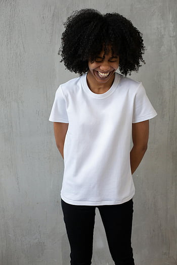 svart kvinna, afro frisyr, skrattande, glad kvinna, lockigt hår, vit t-shirt, svarta jeans, stående inomhus, naturligt hår, leende, Casual outfit