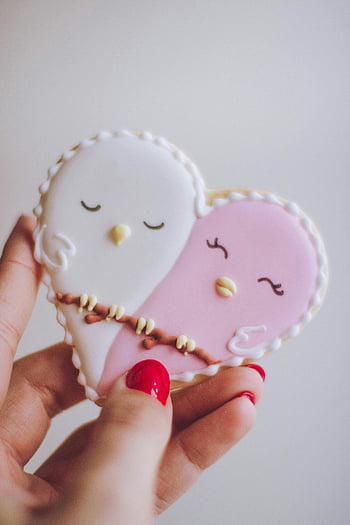 heart-shaped cookie, bird design, white bird, pink bird, hand holding, delightful cookie, Valentine's Day, cute cookie, bird ornament, red nails, sweet treat