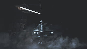 grayscale photography, man leaning, car, hooded person, foggy garage, dimly lit, confident stance, urban scene, atmospheric mood, monochrome image, automotive backdrop