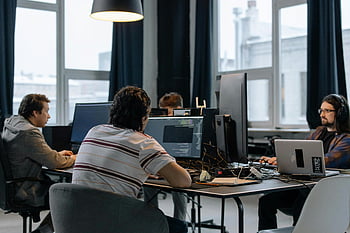 developers working, modern tech office, men using computers, team collaboration, office desks, programming environment, tech workspace, computer screens, professional setting, workplace productivity, coding team