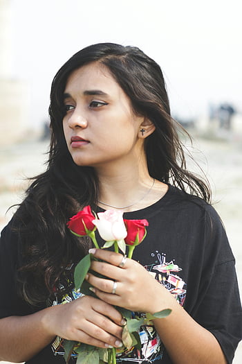 mladá dívka, Černá košile, čerstvé růže, Patna Indie, venkovní portrét, ležérní oblečení, Promyšlený pohled, Mladá žena, drží růže, neformální oblečení, venkovní nastavení