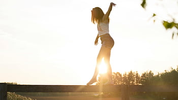 woman walking on fence, young woman, balancing on fence, serene sunrise, freedom, joy, outdoor activity, sunrise photography, rural scene, balance, nature