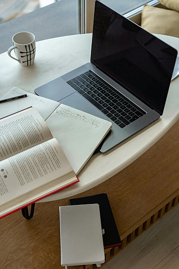 Macbook Pro, white table, cozy workspace, laptop, open book, notepad, coffee, studying, remote work, indoor workspace, workspace setup