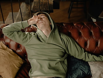 man, groene hoodie, resting, bruine leren bank, gezellige sfeer, ontspannen thuis, binnenomgeving, comfortabele bank, Vrijetijdsoutfit, woonkamer, huisdecoratie