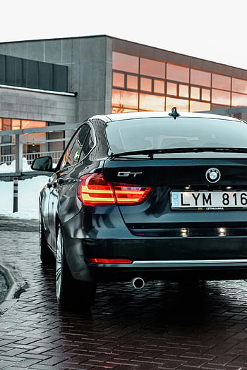 BMW GT、 駐車中の黒い車、 洗練されたテールライトデザイン、 近代建築の背景、 背面図、 リトアニアのナンバープレート、 都会の環境、 高級車、 現代建築、 冬景色、 レンガ舗装