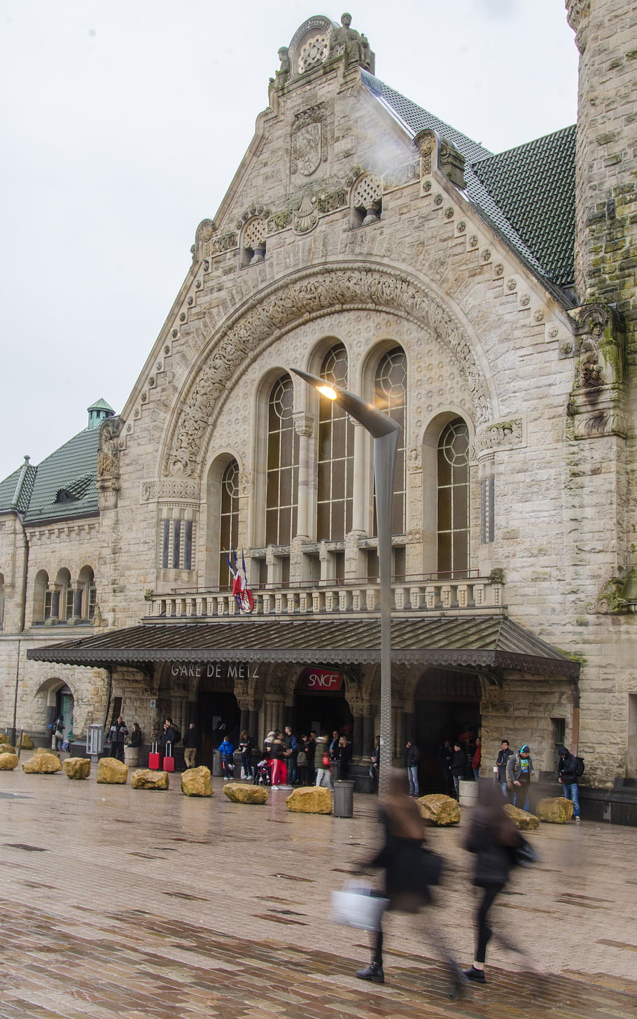 Metz, Gare de Metz, train station, stained glass windows, rain, people walking, General de Gaulle Square, Rhenish neo-Romanesque, tower, clock, columns