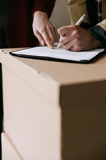leasing, lease documents, signing lease, cardboard box, apartment, hands writing, white paper, document signing, real estate, moving, lease agreement