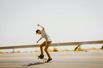 skateboarding, young man, open road, tricks, skill, motion, bright daylight, skateboard, outdoor activity, action shot, dynamic movement