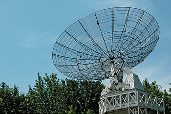 satellite dish, transmission, large satellite dish, clear blue sky, greenery, outdoor technology, communication equipment, satellite communication, outdoor satellite dish, technology infrastructure, satellite antenna