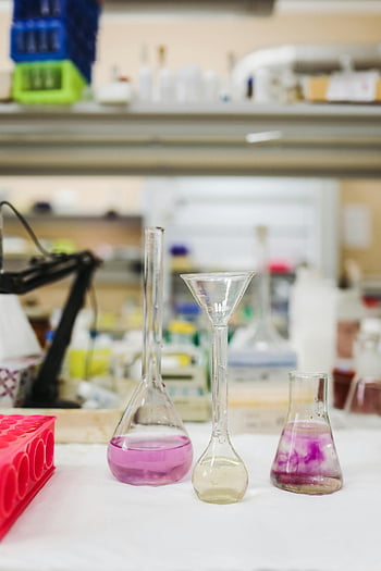 glass lab equipment, chemicals in beakers, vibrant hues, modern lab setting, laboratory glassware, scientific equipment, chemical solutions, lab chemicals, laboratory setting, beakers with liquids, lab experiments
