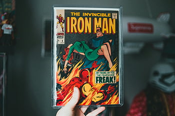 Iron Man, vintage comic book, classic comic book, superhero imagery, invincible Iron Man, comic book cover, retro comic, Marvel comics, iconic superhero, comic book art, hand holding comic