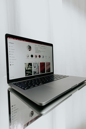 laptop, Instagram profile, modern technology, online connectivity, sleek laptop, table reflection, display screen, social media, digital device, web browsing, computer interface